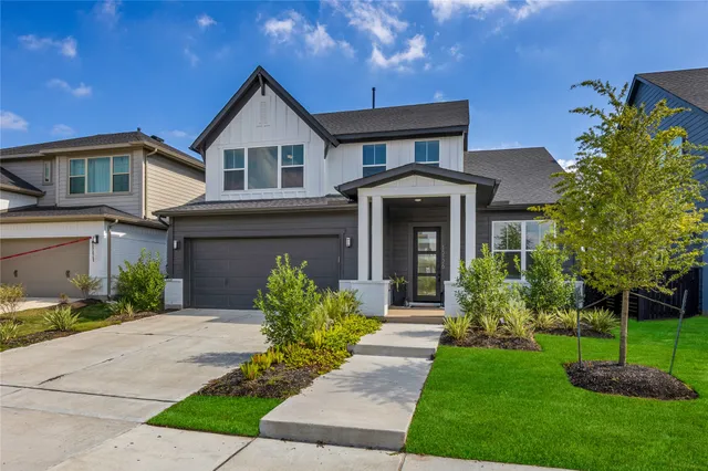 a front view of a house with a garden and plants