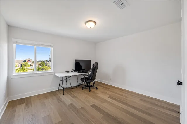 a view of a room with wooden floor and windows