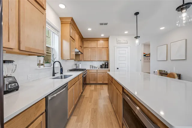 a large kitchen with stainless steel appliances lots of counter space and a sink