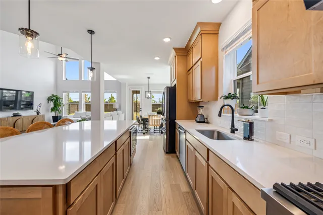 a living room with furniture potted plant floor to ceiling window and a flat screen tv