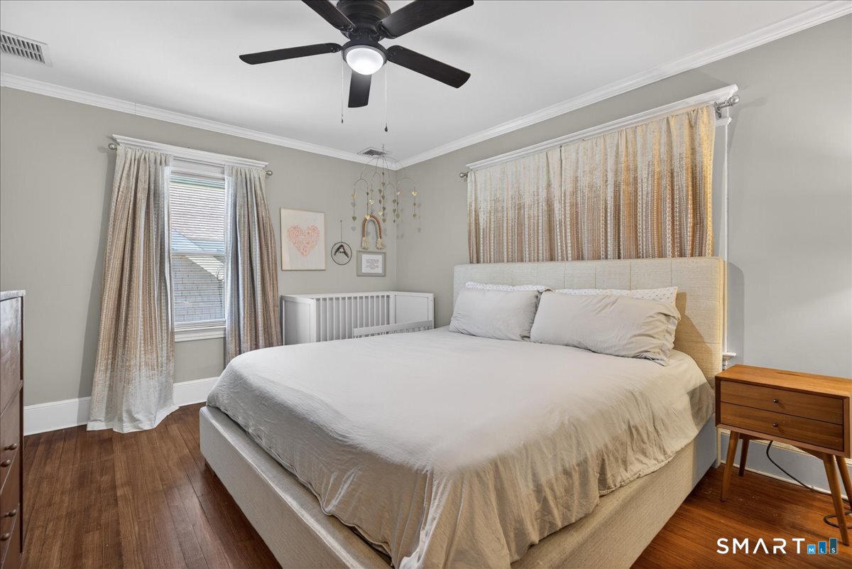 144 Mather Street Hamden, CT 06517 - Photo 20 of 40 a bedroom with a large bed and a chandelier