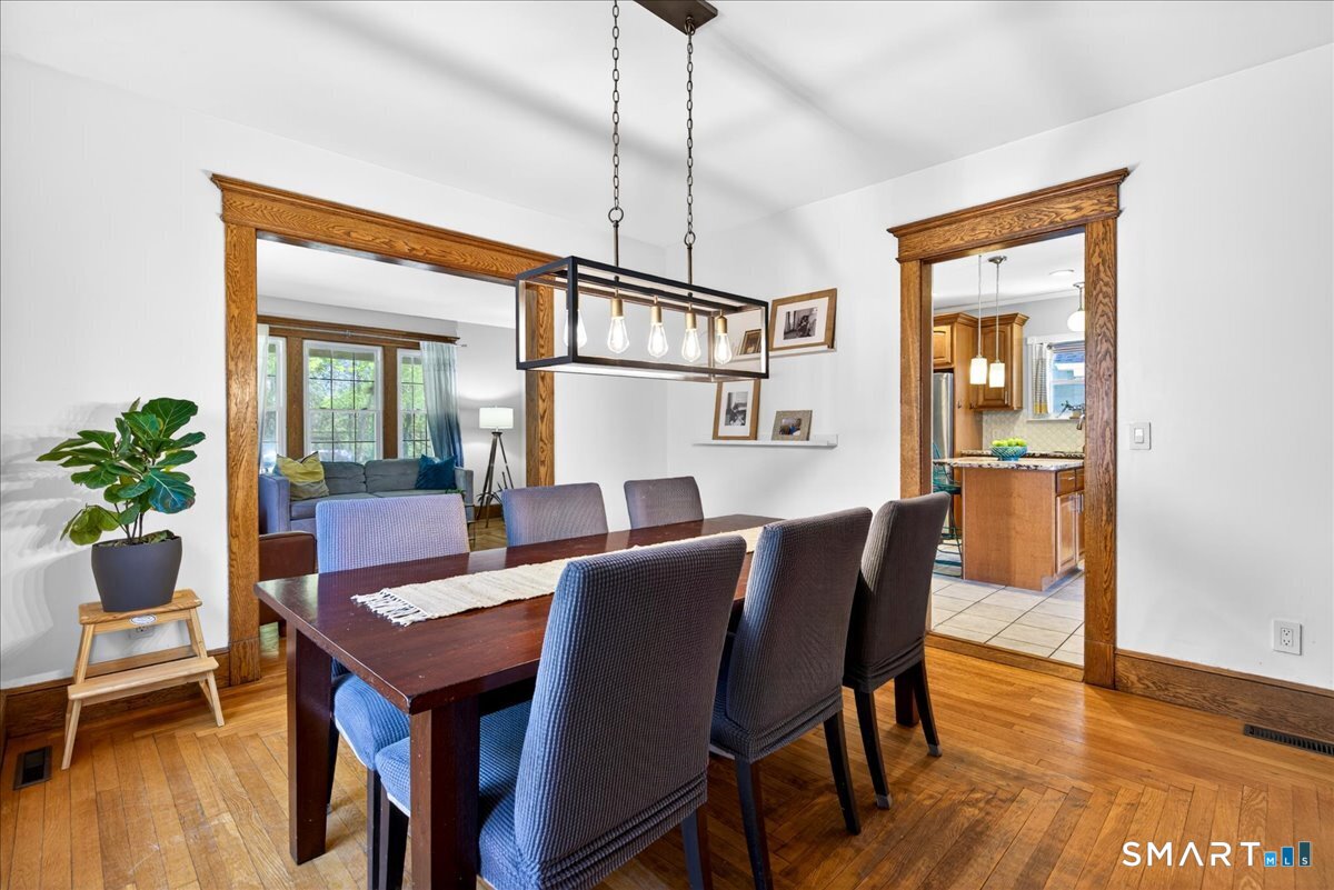 144 Mather Street Hamden, CT 06517 - Photo 8 of 40 a dining room with furniture a rug a potted plant and wooden floor
