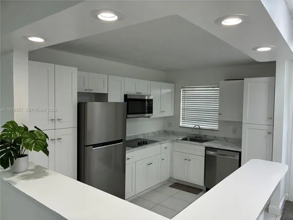 a kitchen with a refrigerator and a white cabinets