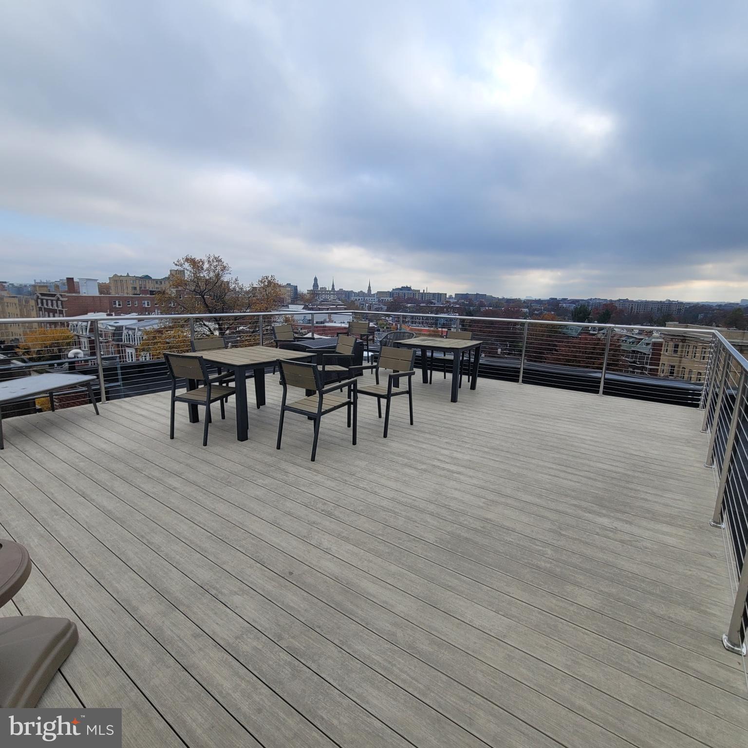1673 Park Road Northwest, Unit 502 Washington, DC 20010 - Photo 15 of 23 a view of a roof deck dining table and chairs with wooden floor