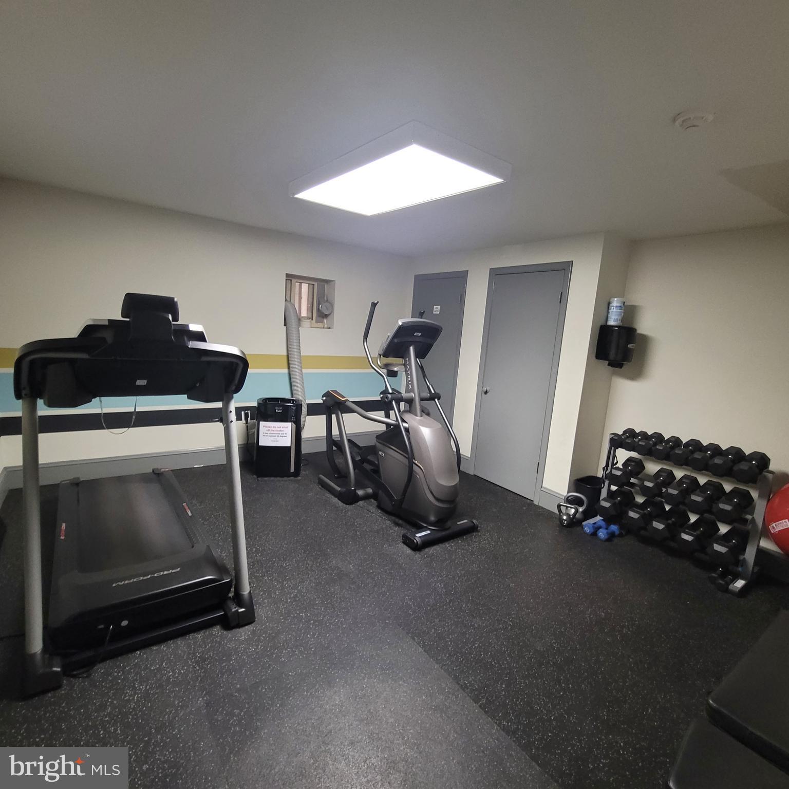 1673 Park Road Northwest, Unit 502 Washington, DC 20010 - Photo 19 of 23 a room with gym equipment and a fireplace