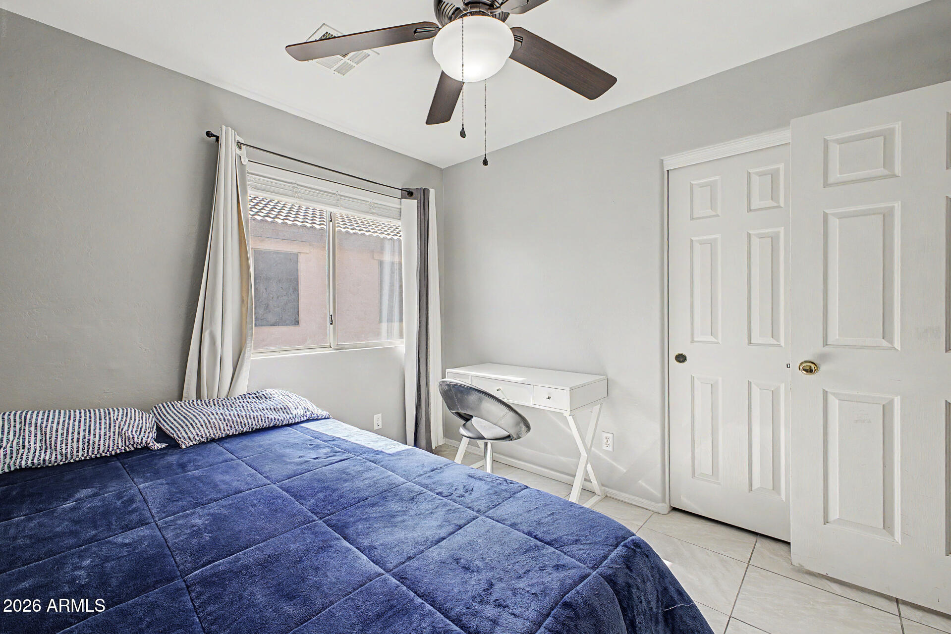 17236 West Durango Street Goodyear, AZ 85338 - Photo 12 of 14 a bedroom with a bed and a chandelier