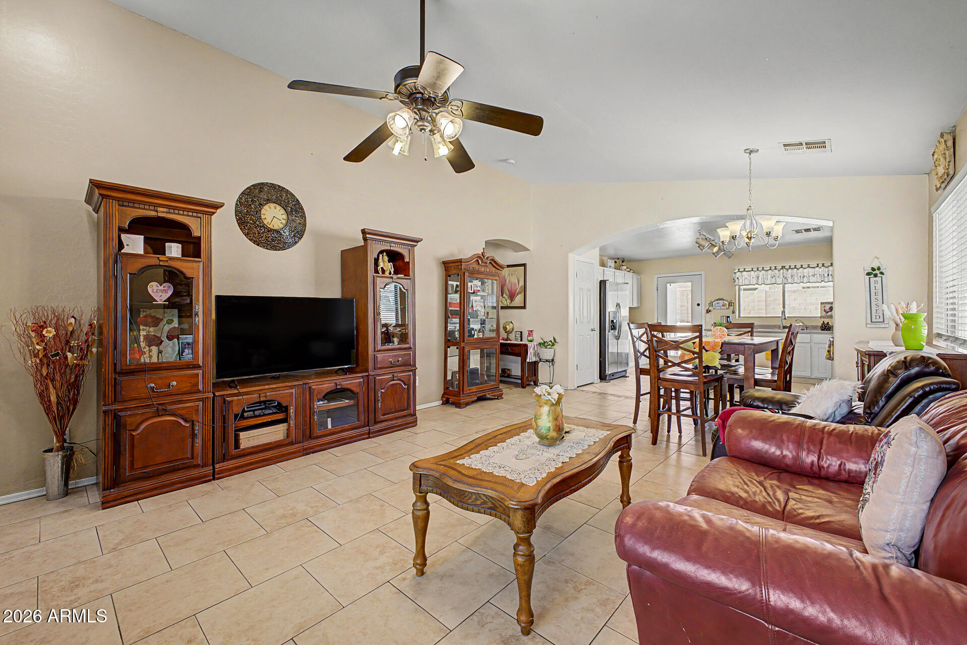 17236 West Durango Street Goodyear, AZ 85338 - Photo 4 of 14 a living room with furniture a flat screen tv and kitchen view
