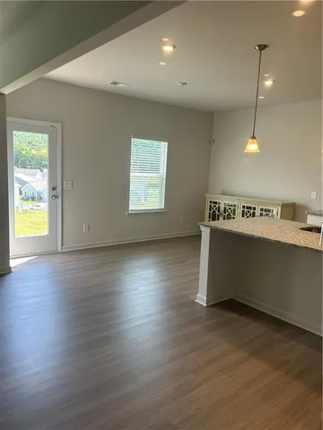 an empty room with wooden floor and natural light