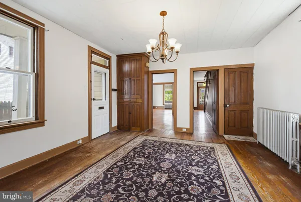 a kitchen with stainless steel appliances granite countertop a refrigerator a sink dishwasher and white cabinets with wooden floor