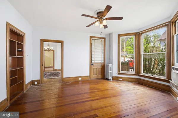 a view of a hallway with wooden floor and a livingroom