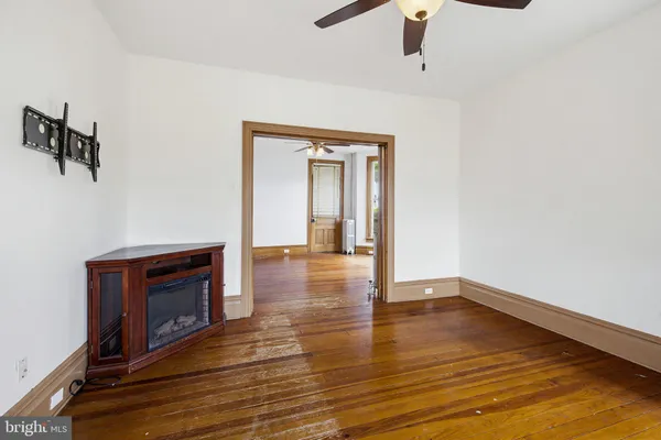 an empty room with a ceiling fan and window