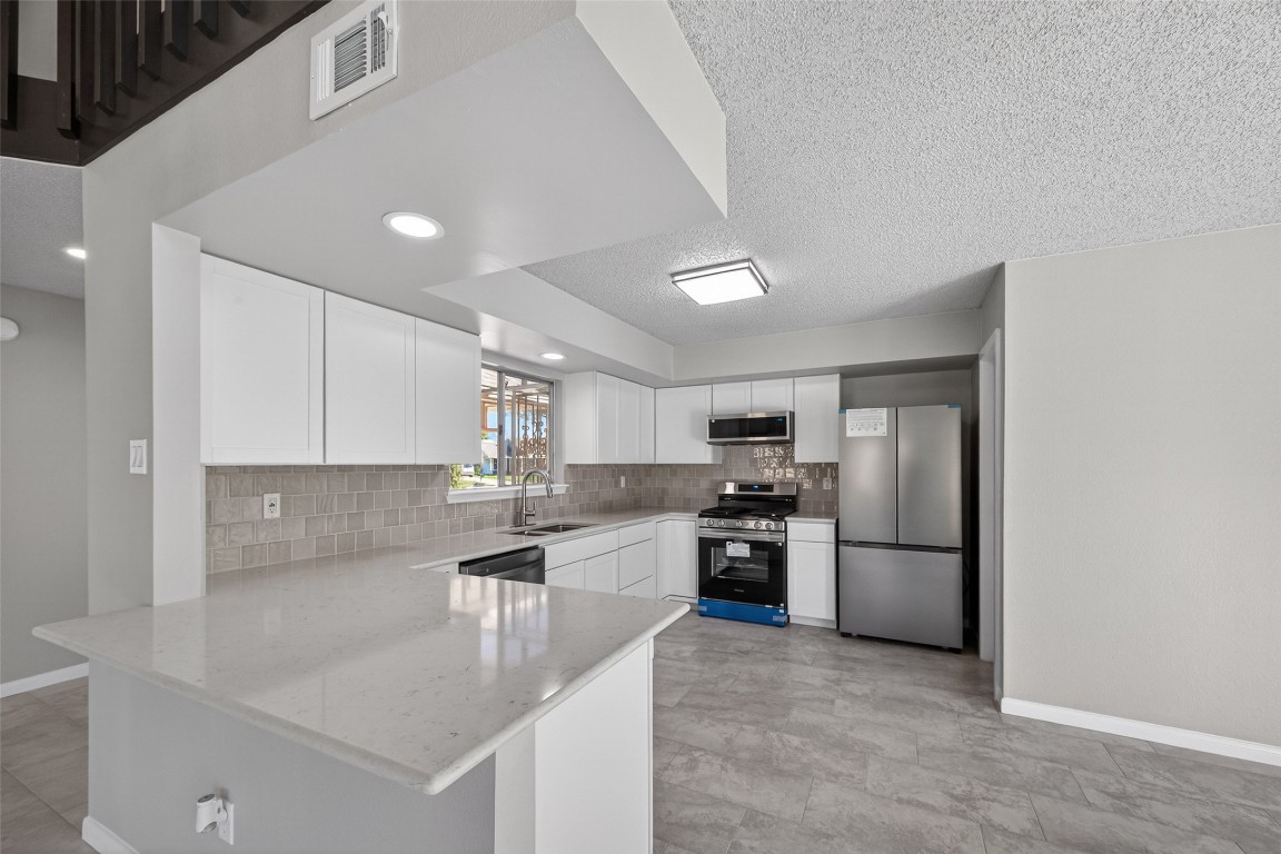 11406 Caesar Drive Houston, TX 77477 - Photo 2 of 32 a kitchen with stainless steel appliances granite countertop a sink stove and refrigerator