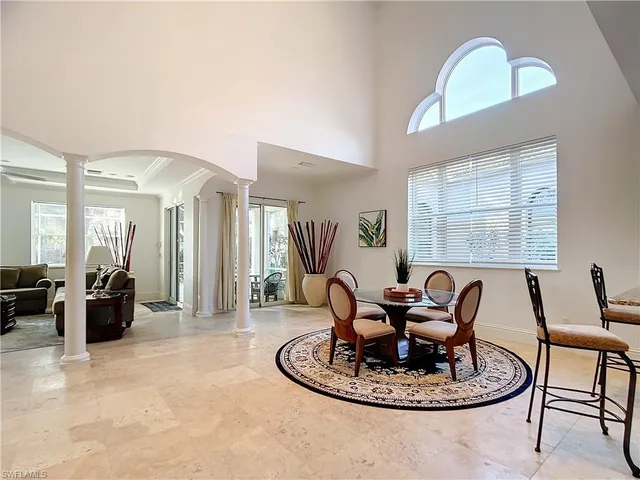 a living room with furniture chandelier and a large window