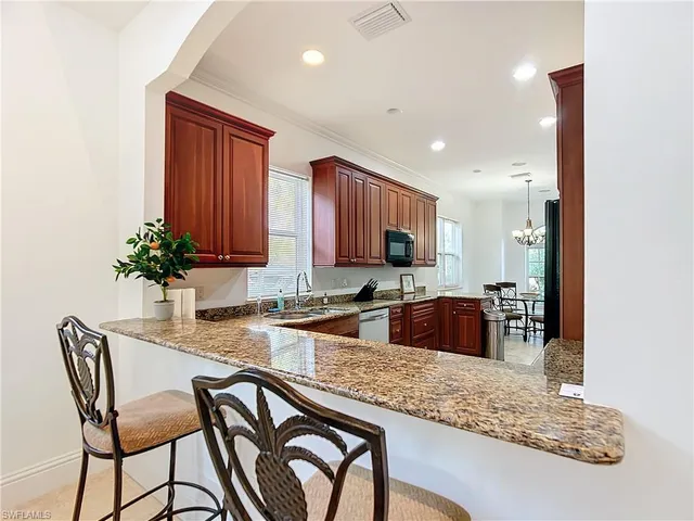 a kitchen with stainless steel appliances granite countertop a sink and a refrigerator