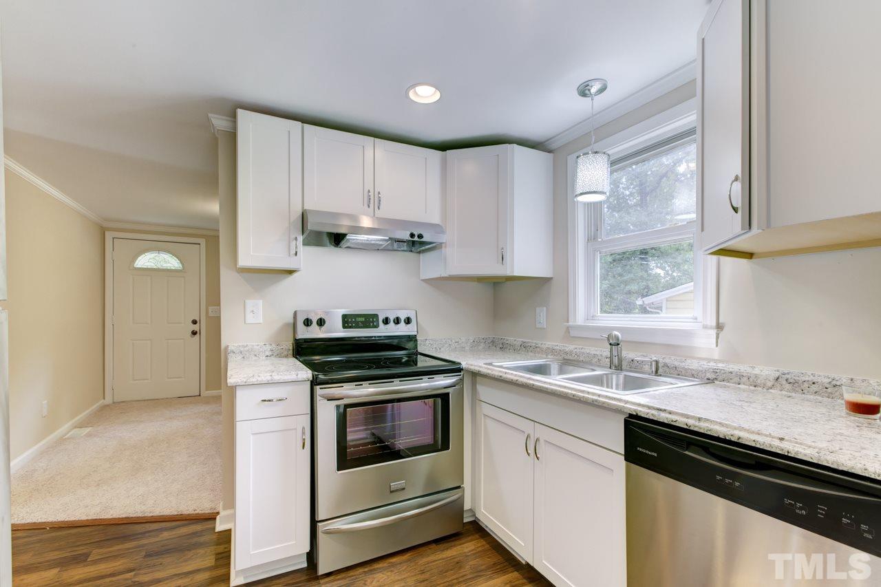 2308 Lilac Lane Raleigh, NC 27612 - Photo 6 of 25 a kitchen with stainless steel appliances granite countertop a sink stove cabinets and refrigerator