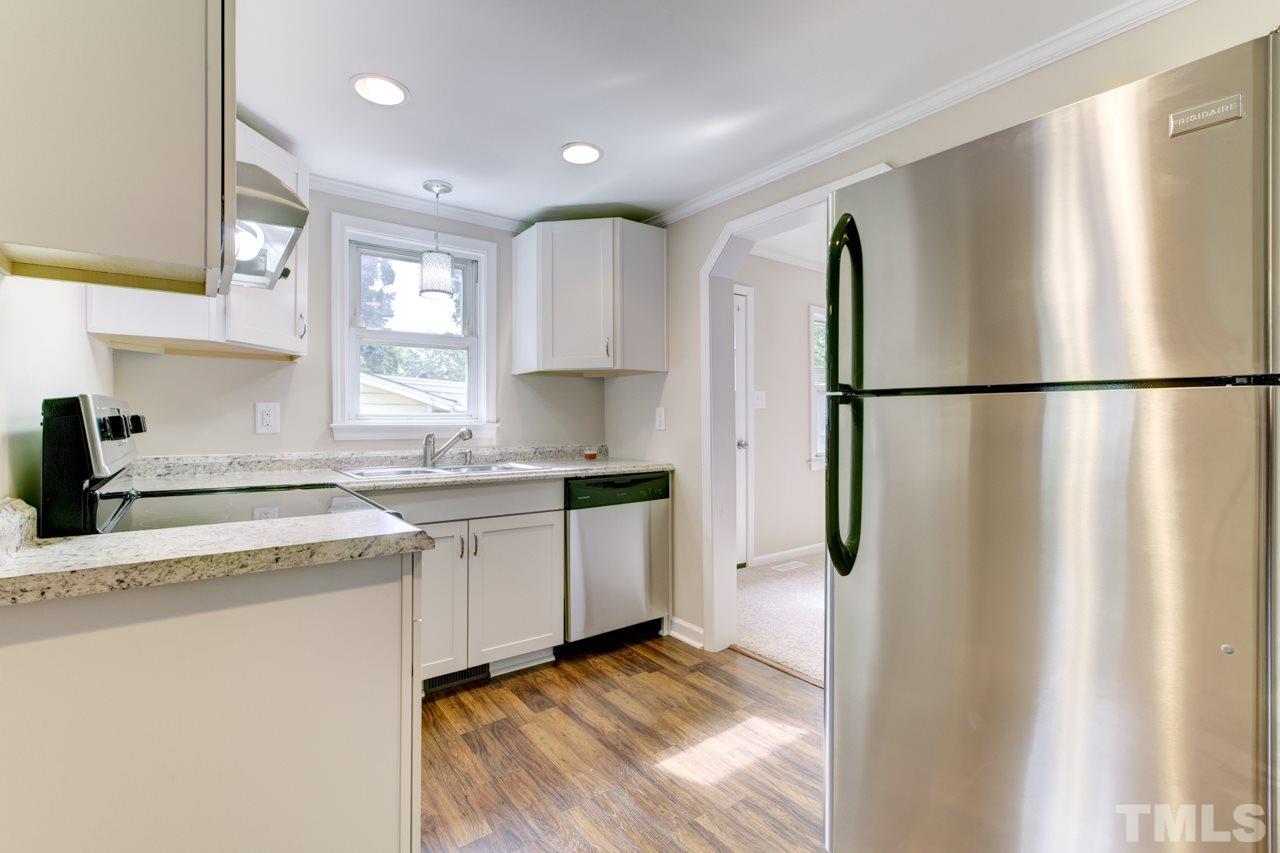 2308 Lilac Lane Raleigh, NC 27612 - Photo 7 of 25 a kitchen with a refrigerator a sink and cabinets