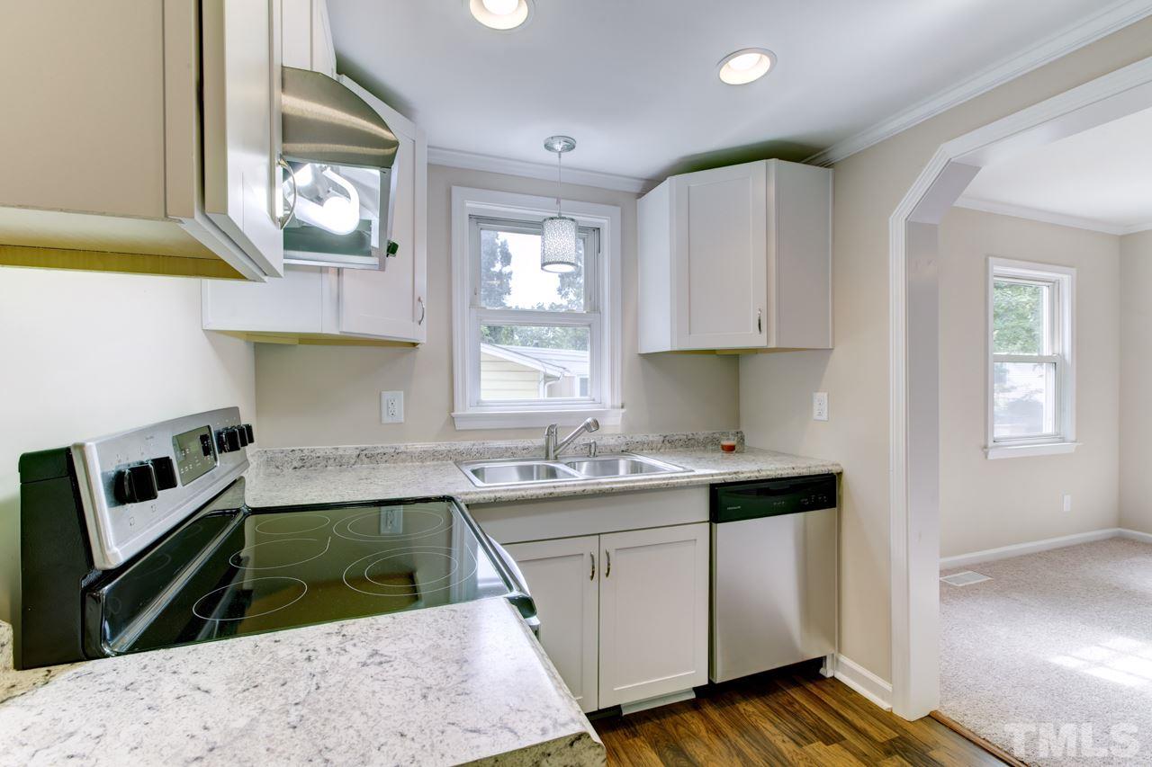 2308 Lilac Lane Raleigh, NC 27612 - Photo 8 of 25 a kitchen with stainless steel appliances granite countertop a sink stove and cabinets