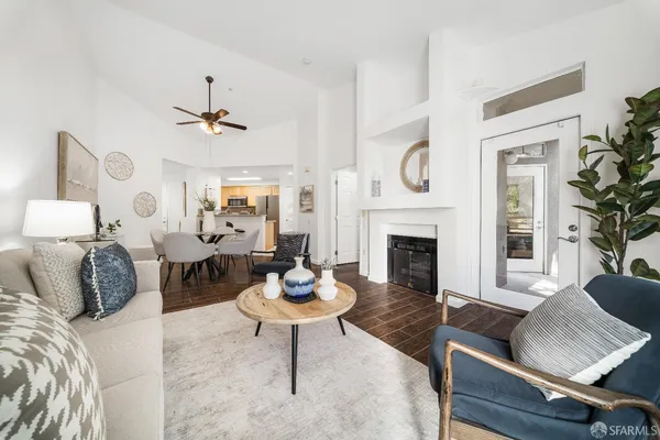 a living room with furniture a fireplace and a chandelier