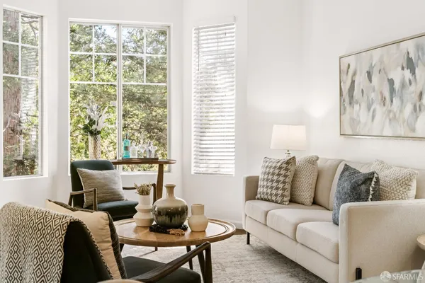 a living room with furniture and a painting on the wall