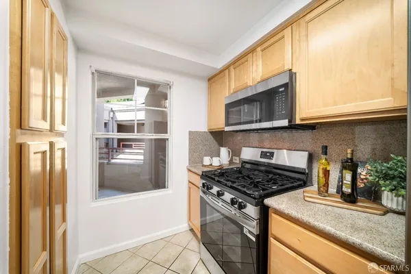a kitchen with a sink and a stove with wooden floor