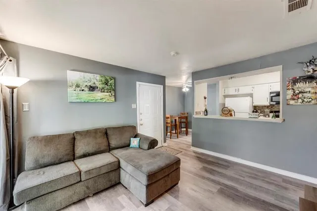 a living room with furniture and a view of kitchen