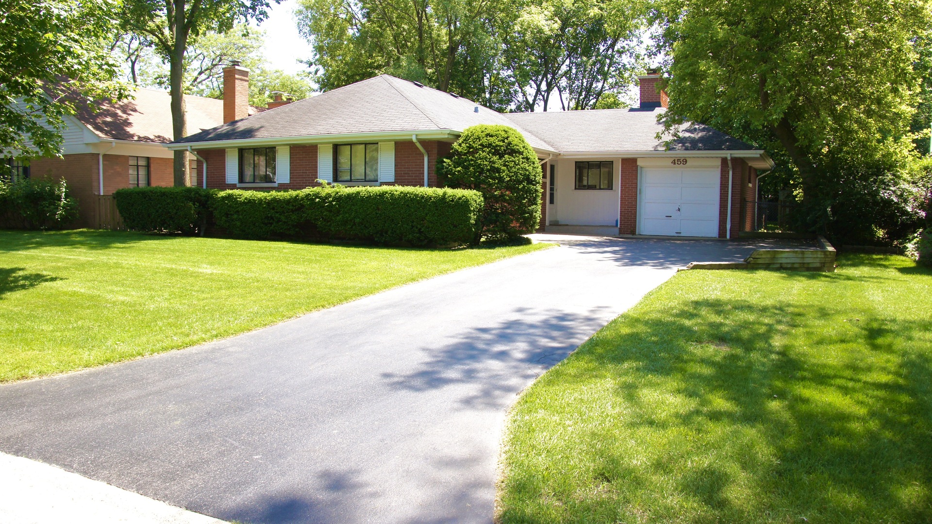 a front view of a house with a yard and trees