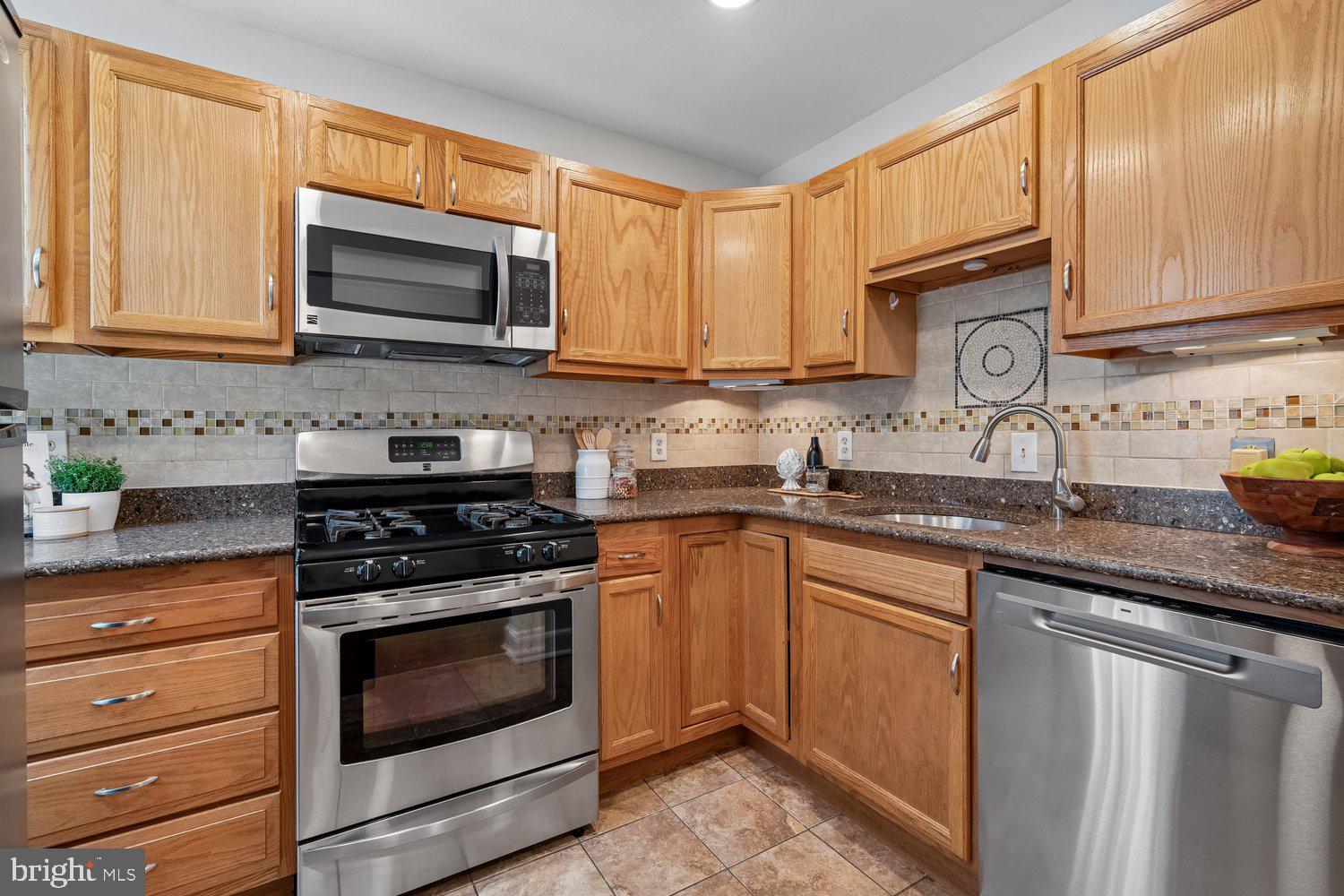 1652 Kramer Street Northeast Washington, DC 20002 - Photo 4 of 26 a kitchen with granite countertop a stove top oven sink and cabinets