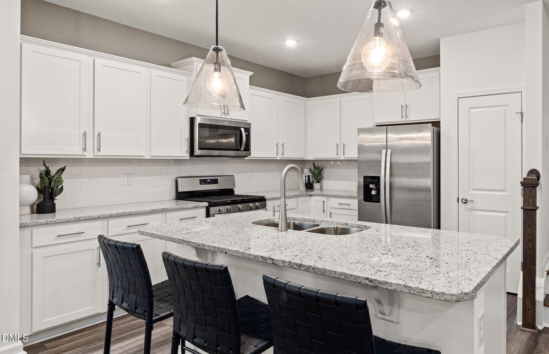 5020 Reader Way Durham, NC 27703 - Photo 3 of 32 a kitchen with kitchen island granite countertop a sink a center island and stainless steel appliances