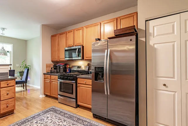 a kitchen with stainless steel appliances granite countertop a refrigerator and a stove top oven