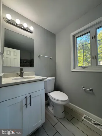 a bathroom with a toilet a sink and mirror