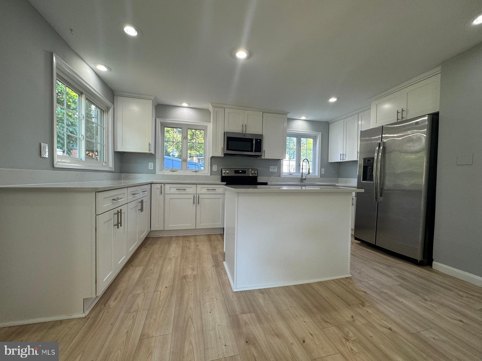 5735 Euclid Street Landover, MD 20785 - Photo 6 of 14 a large kitchen with stainless steel appliances granite countertop a stove a sink dishwasher a microwave oven and a refrigerator with wooden floor