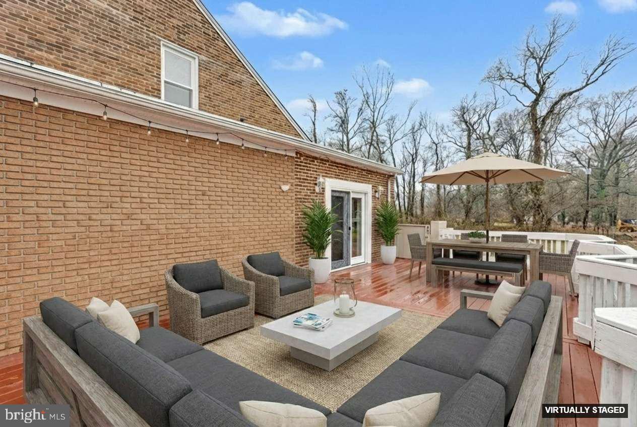 2810 & 2810-a 12th Street Baltimore, MD 21219 - Photo 15 of 67 a view of a patio with couches table and chairs with wooden floor and fence