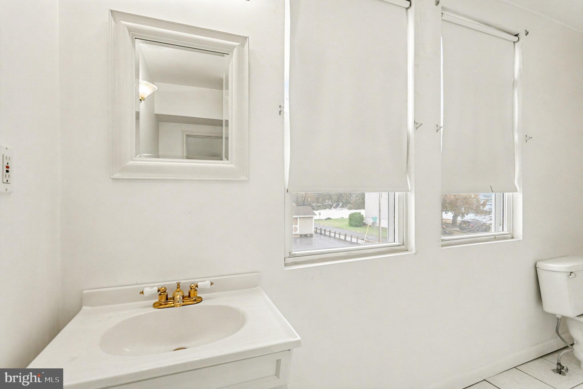 2810 & 2810-a 12th Street Baltimore, MD 21219 - Photo 35 of 67 a bathroom with a sink mirror and a toilet