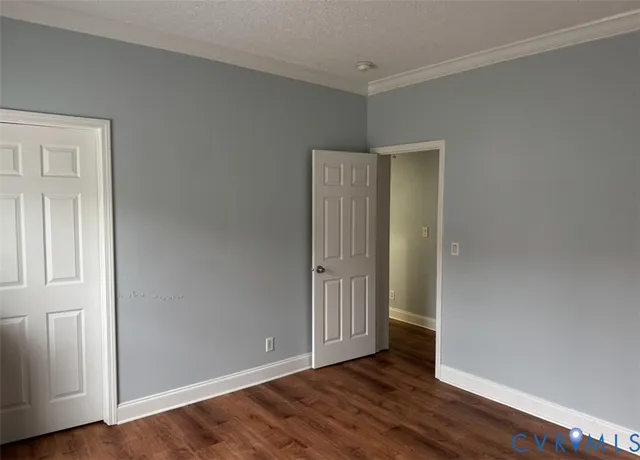 an empty room with wooden floor and closet