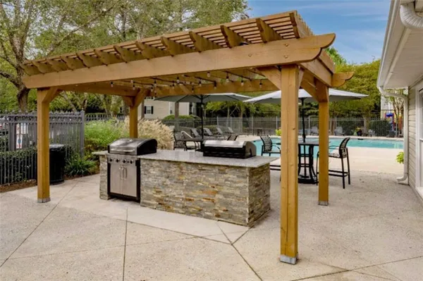 a view of a patio with a table and chairs under an umbrella