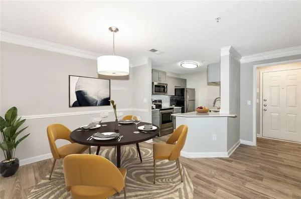 a dining room with furniture a chandelier and wooden floor