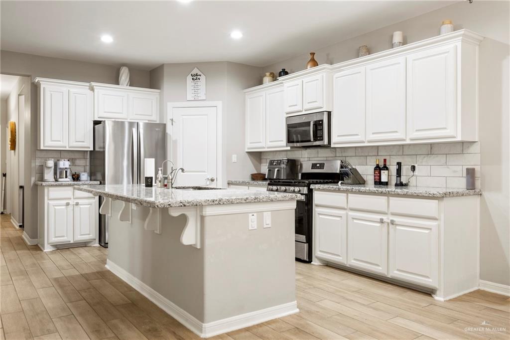 6332 Cascada Bnd Road McAllen, TX 78504 - Photo 4 of 18 a kitchen with stainless steel appliances granite countertop a refrigerator sink and white cabinets