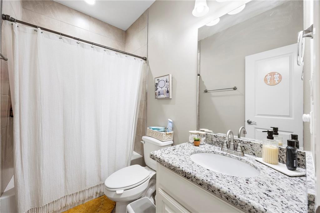 6332 Cascada Bnd Road McAllen, TX 78504 - Photo 9 of 18 a bathroom with a granite countertop sink and a mirror