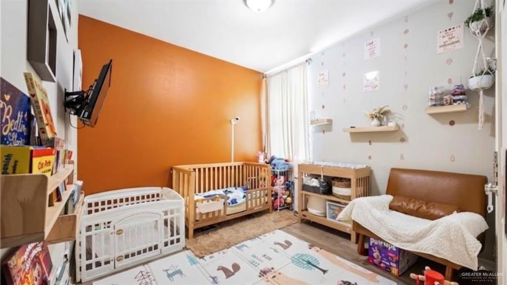 6332 Cascada Bnd Road McAllen, TX 78504 - Photo 10 of 18 a bedroom with furniture and a wooden floor