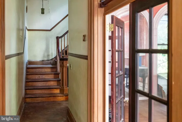 a view of a hallway with wooden floor and windows