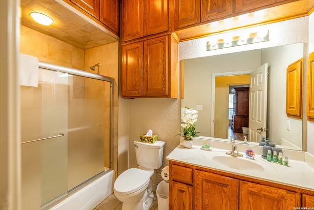 a bathroom with a granite countertop sink toilet and shower