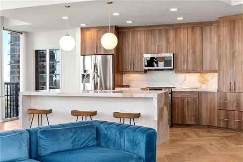 a kitchen with stainless steel appliances granite countertop a stove a sink and a microwave