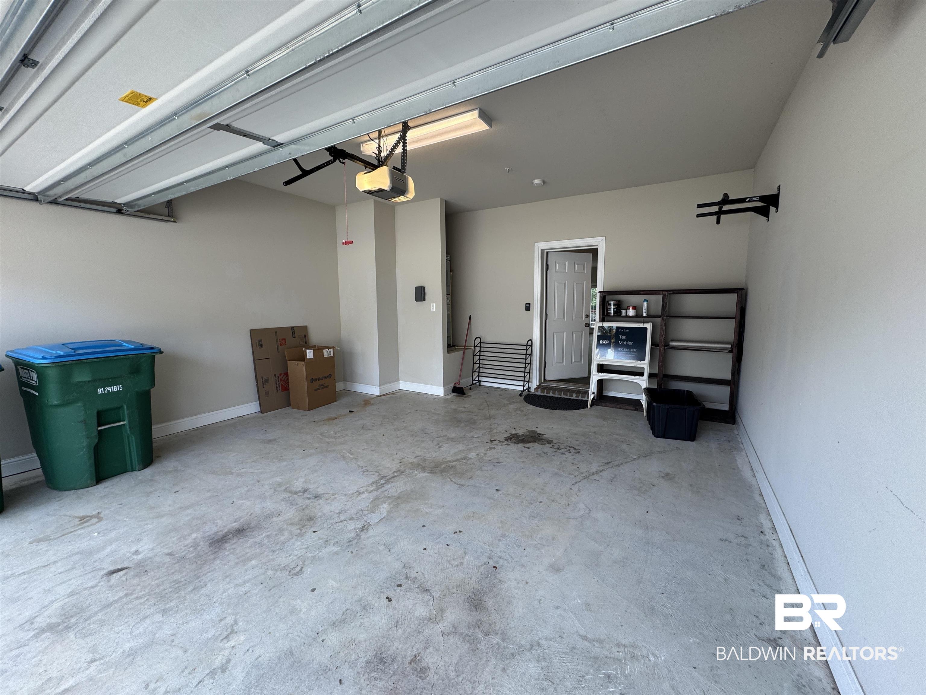 6811 Spaniel Drive, Unit C Daphne, AL 36527 - Photo 24 of 33 Garage featuring a garage door opener and baseboards