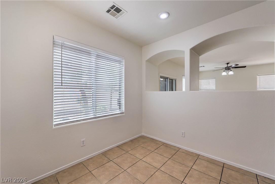 10939 Paradise Road Henderson, NV 89052 - Photo 11 of 36 Functional room features arched openings and neutral tiled flooring, ready for your personalized touch.