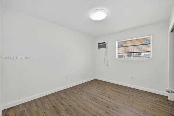 a view of a room with wooden floor and white walls
