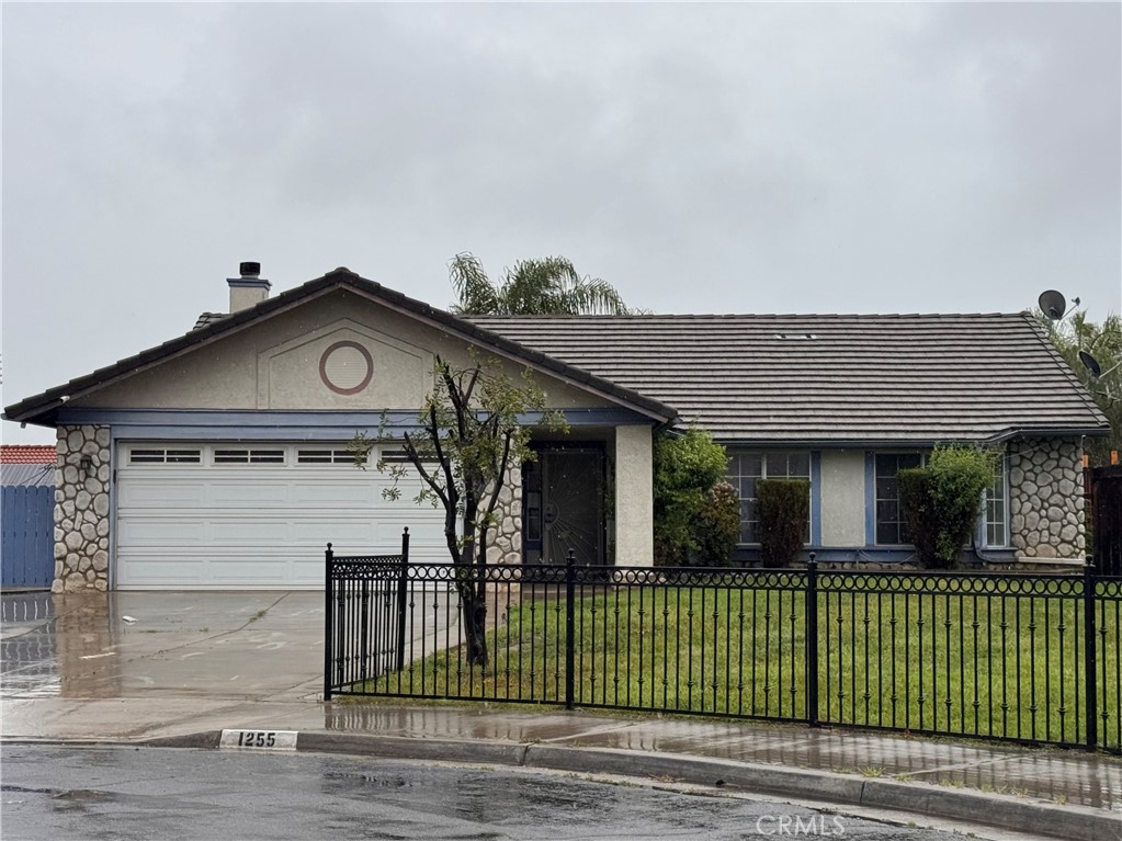 1255 Comiskey Court Perris, CA 92571 - Photo 1 of 3 a front view of a house with a garden