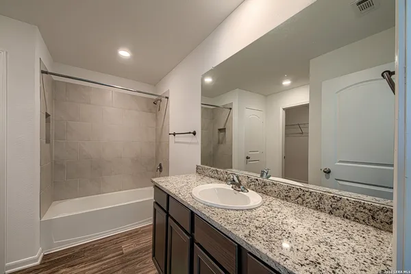 a bathroom with a granite countertop sink and a mirror