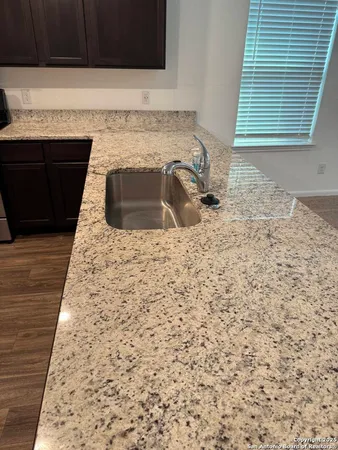 a bathroom with a granite countertop sink and a bathtub