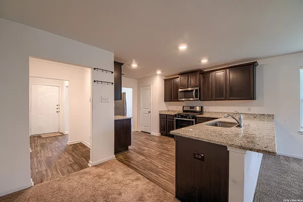 a kitchen with stainless steel appliances granite countertop a sink refrigerator and microwave