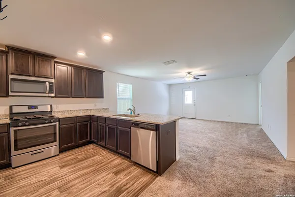 a kitchen with stainless steel appliances granite countertop a stove a sink dishwasher and a refrigerator